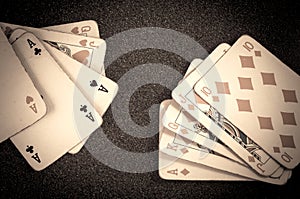 Poker royal straight flush and three of a kind vintage cards on a table background