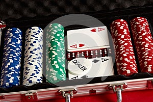 Poker set in metal suitcase. Risky entertainment of gambling. Top view on red background