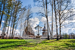 The Pokrovskaya church, the bellfry and the wayside cross behind the birch trees.