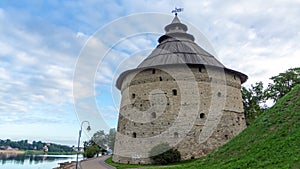 Pokrovskaya fortress tower on the shore of the Velikaya river on a sunny day