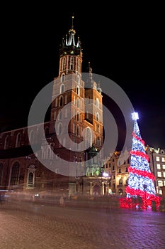 Poland, Krakow, Main Market square and Cloth Hall in winter, during Christmas fairs decorated with Christmas tree.