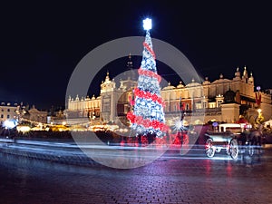 Poland, Krakow, Main Market square and Cloth Hall in winter, during Christmas fairs decorated with Christmas tree. photo