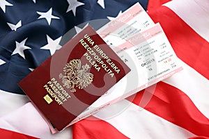 Poland passport with airline tickets on American US flag close up. Tourism and travel