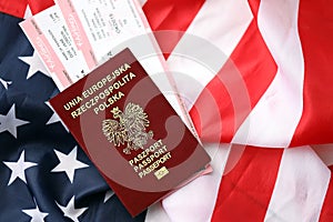 Poland passport with airline tickets on American US flag close up. Tourism and travel