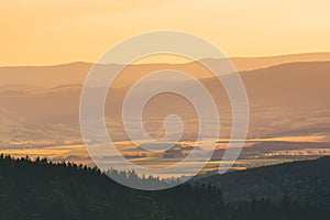 Poland, the Sudetes, mountain landscape in the Snieznik massif, mountain peaks and a valley illuminated by the rays of the sun