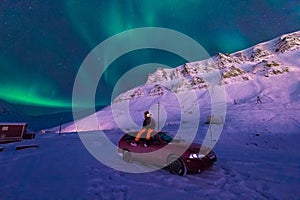 The polar arctic man Northern lights aurora borealis sky star in Norway Svalbard in Longyearbyen city moon mountains