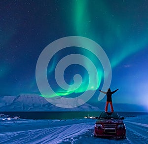 The polar arctic man Northern lights aurora borealis sky star in Norway Svalbard in Longyearbyen city moon mountains