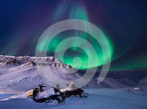 The polar arctic Northern lights aurora borealis sky star in Norway Svalbard Longyearbyen city snowscooter mountains