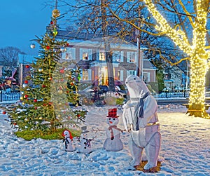 Polar bear family land Christmas tree lit up at night