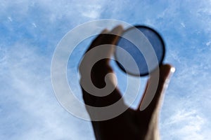 Polarizing filter on a blue sky background. Optics tool for lens in photography. Selective focus