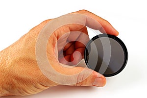 Polarizing filter in hand on a white background