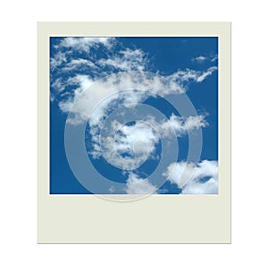 Polaroid photo frame with blue sky and clouds