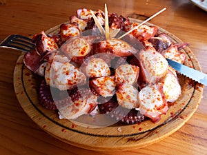 Galician-style octopus a traditional Galician dish served on the wooden plate photo