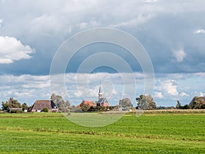Polder with grassland, farmhouse and church of Cornjum, Friesland, Netherlands