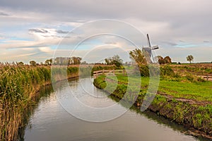 Polder landscape with curved ditch and windmill