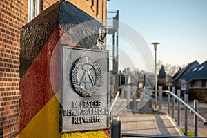 pole with the coat of arms of the GDR stands in a village