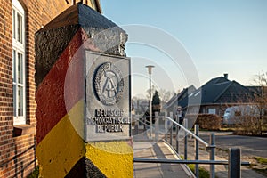 pole with the coat of arms of the GDR stands in a village photo