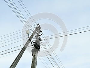 A pole with electrical wires. Power grid. Cable network on a pole. Wires in a mess on a pole.