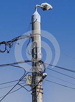 A pole full of cables under the blue sky