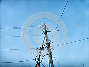 A pole with a lantern and a lot of wires against the background of the evening or night sky. Lighting and power line