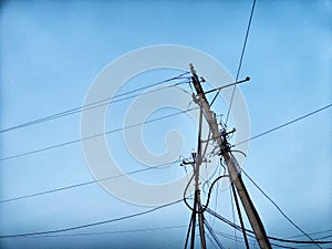A pole with a lantern and a lot of wires against the background of the evening or night sky. Lighting and power line