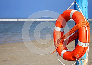 Pole with lifejacket at sea on the beach 2