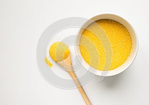 Polenta or Cornmeal Flour. Ground Dried Corn or Corn Grits in a white bowl and wooden spoon close-up