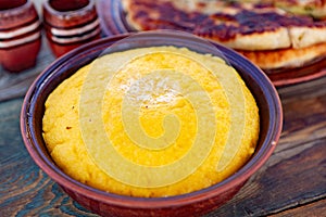 Polenta is a dish made from corn flour, served with a book and cheese.