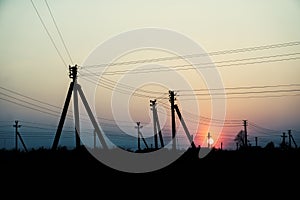 Poles of electrical lines in the sunset background