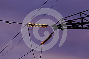 Poles at a power plant at sunset as a background