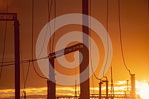 Poles at a power plant at sunset as a background