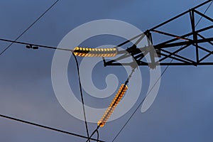 Poles at a power plant at sunset as a background