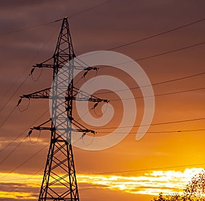 Poles at a power plant at sunset as a background