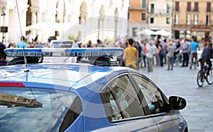 Police car with blue sirens in the main square of the city