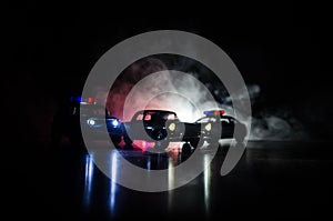 Police car chasing a car at night with fog background. 911 Emergency response police car speeding to scene of crime