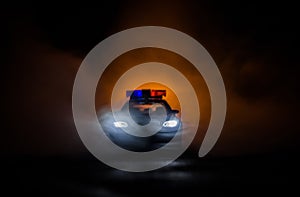 Police car chasing a car at night with fog background. 911 Emergency response police car speeding to scene of crime