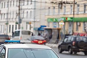 police car lights in city street with civilian cars traffic in blurry background in Tula, Russia