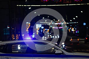 police car with lights in night city, closeup side view with selective focus