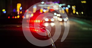 Police car lights in night city with selective focus and bokeh