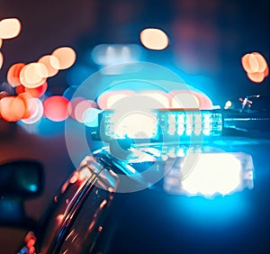 Police car lights at night in city with selective focus and bokeh. Generative AI