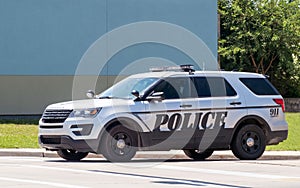 Police car parks on a street watching local traffic