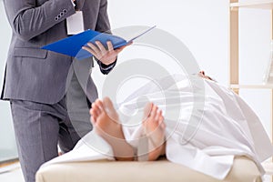 The police coroner examining dead body corpse in morgue