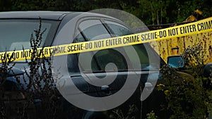 Police Crime Scene Cordon Tape Around Junkyard Car