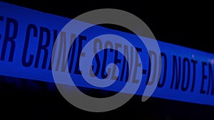 Police Crime Scene Cordon Tape Illuminated by Blue Strobe Light