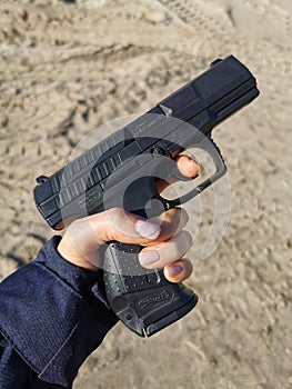 Police gun in a woman`s hand.