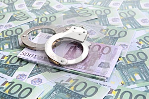 Police handcuffs lies on a set of green monetary denominations o