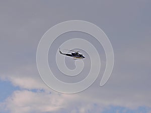 Police helicopter flying in the blue sky by day, side view