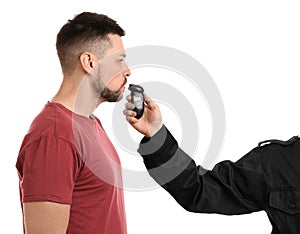 Police inspector conducting alcohol breathe testing, man blowing into breathalyzer on white background