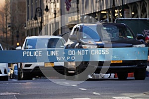 Police line, do not cross NYPD police barricade on Midtown Manhattan street with car traffic
