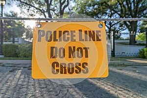Police Line Do Not Cross yellow sign board hanging on a rope close up view